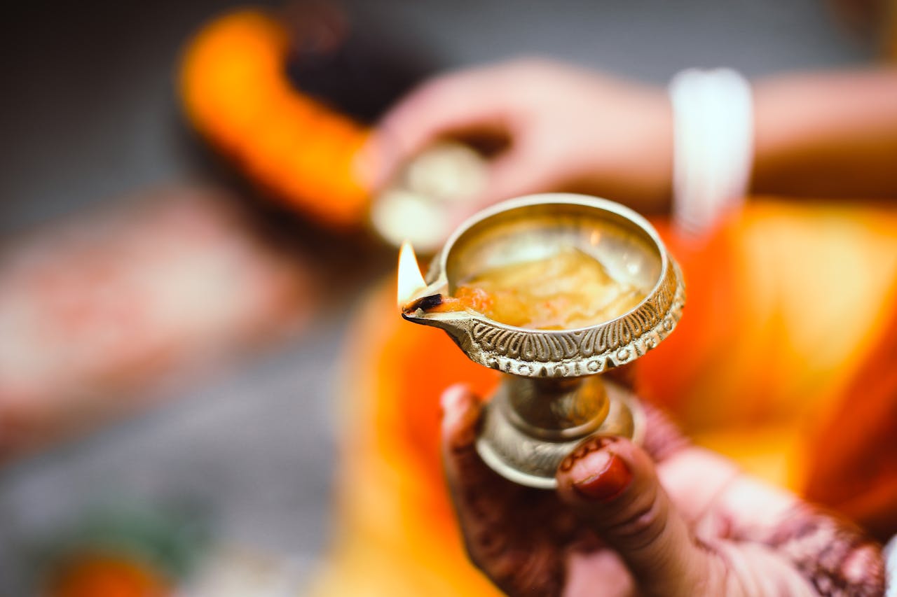 Close-up of a woman holding a decorative candle during a traditional ceremony in Bangladesh.